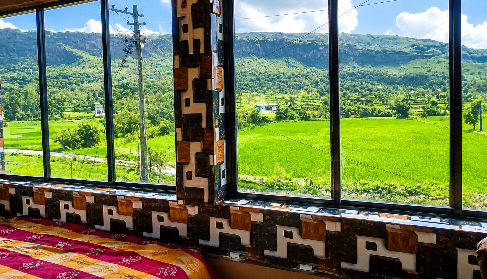 Beautiful view of green fields and mountains from hotel window